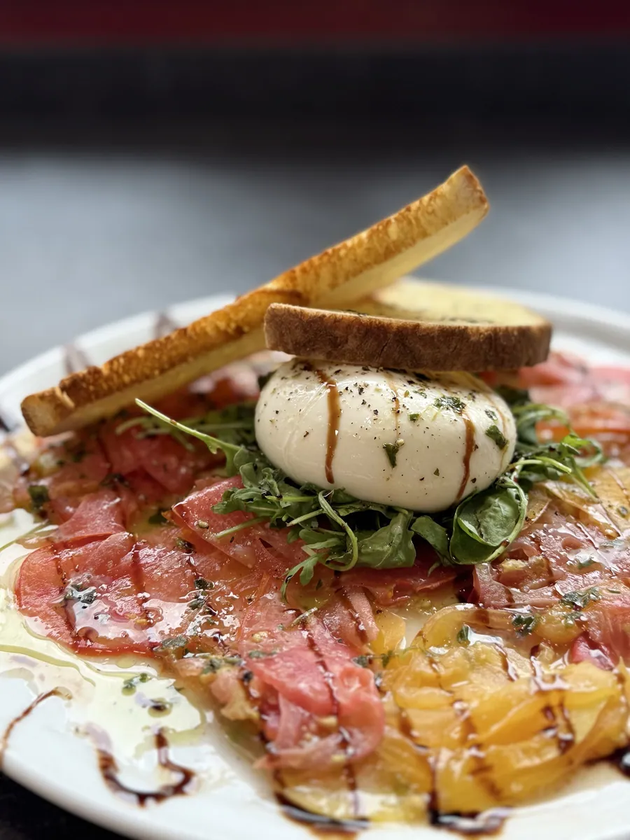 Assiette de carpaccio et burrata servie en entrée au Cristal