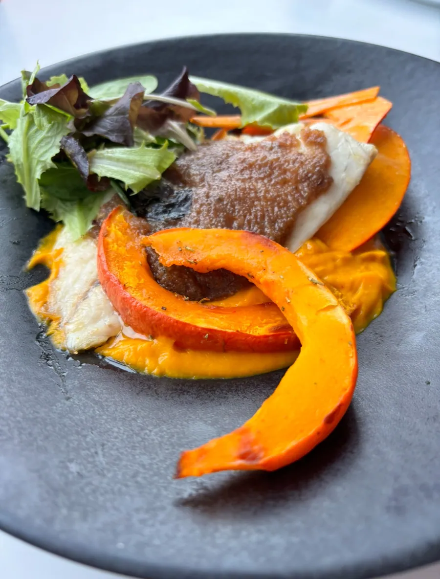 Filet de poisson et potimarron rôti servis sur assiette ardoise
